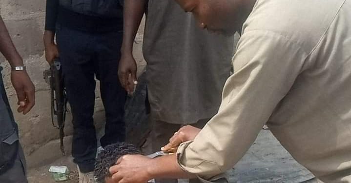 Kogi State administrator was pictured cutting the hair of a young man wearing dreadlocks